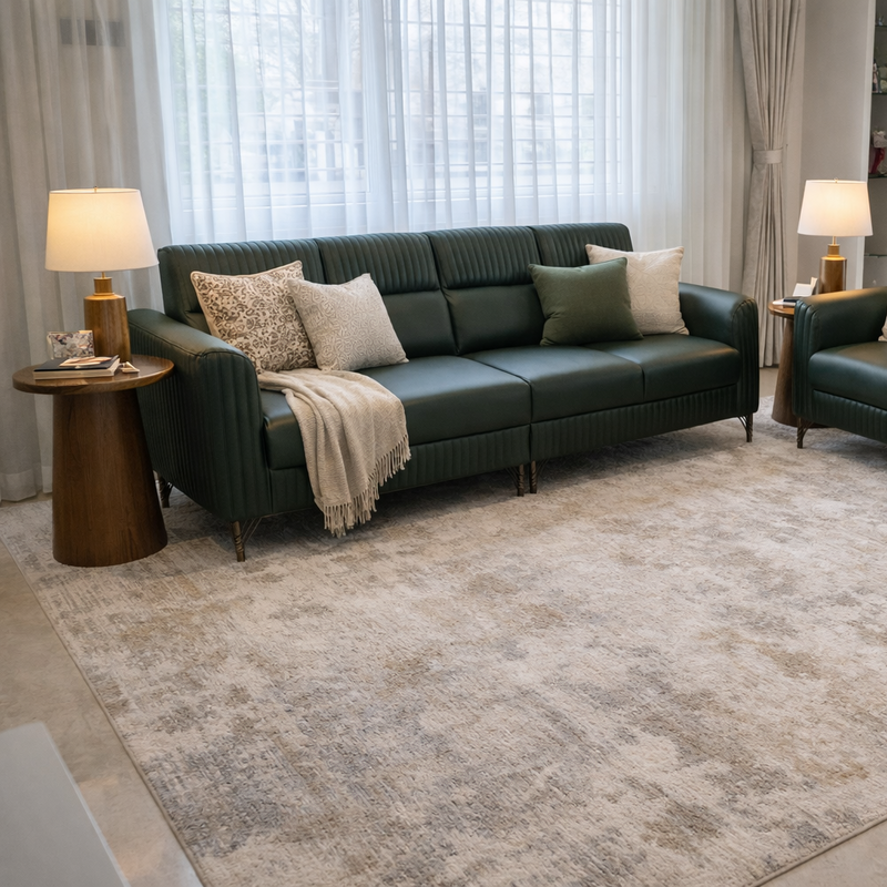 Two dark green leather sofas with cushions and a rug in a living room setting.