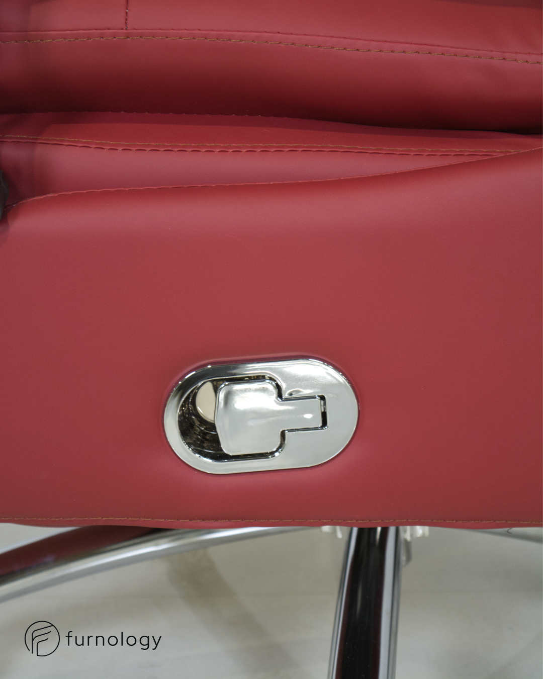 Close-up of red leatherette reclining executive office chair lever and chrome base by Furnology